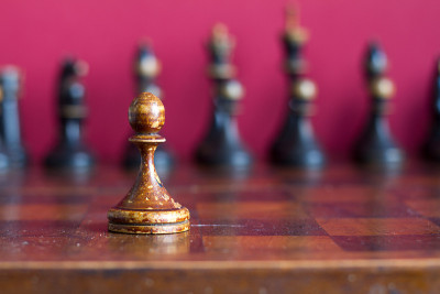 旧棋盘上的老式木制棋子。
