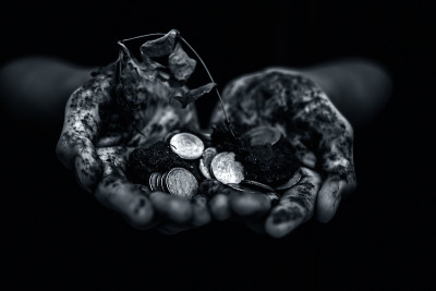 近距离观察满是泥土和一把硬币的手。发现宝藏。持有金银钱币。