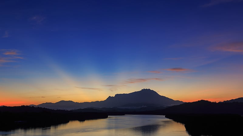 令人惊叹的美丽黎明日出与光线和基纳巴卢山为背景在加阳，图兰，沙巴州，婆罗洲