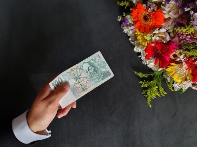 一个商人的手用捷克的钱买了一束花