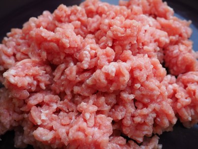 切碎的肉放在一个紫色的陶瓷大盘子里。美味的新鲜碎肉，用于制作肉排，牛排，汉堡，肉丸。猪肉半成品