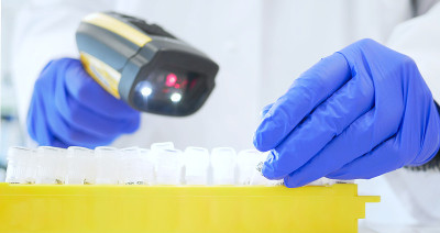 实验室技术员或医疗助理将病人样本扫描到病人数据库中。实验室技术员使用条形码阅读器。基因和癌症筛查以及