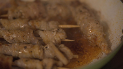 用叉子在平底锅里煮的肉串和蔬菜串