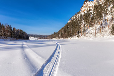 冰封的山间河流上的雪地摩托道