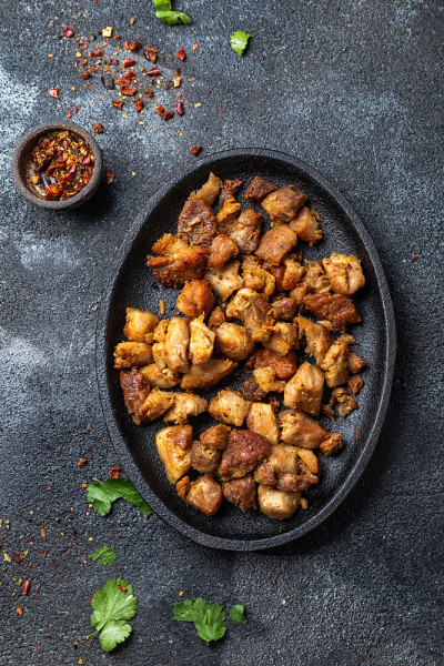 哥伦比亚CHICHARRON。炸猪排放在黑盘子里。俯视图