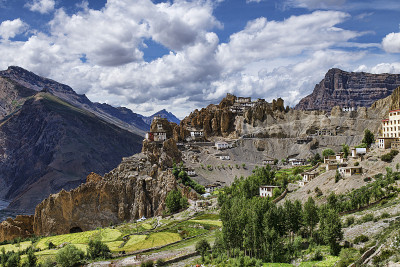 藏式白色建筑在高高的岩石上的丹卡寺全景