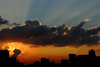 太阳在大城市落下，有云产生美丽的光