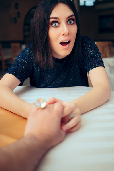 女人拿着订婚戒指向结婚的男友求婚