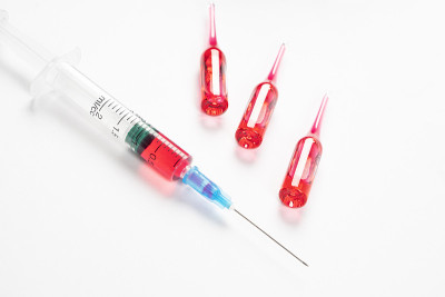 注射器关闭与安瓿在白色的医疗台上。塑料皮下注射器注射疫苗。医用注射器的特写。装有注射和疫苗溶液的注射