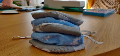 Self-sewing防护面具。桌上放自制的防护口罩和几块布