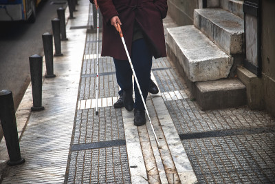 盲人用白色拐杖在街上行走