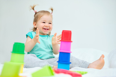 快乐的幼童拍着他的手玩玩具。