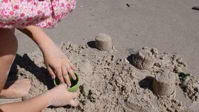 孩子们在海滩上用砂模工具做沙堡