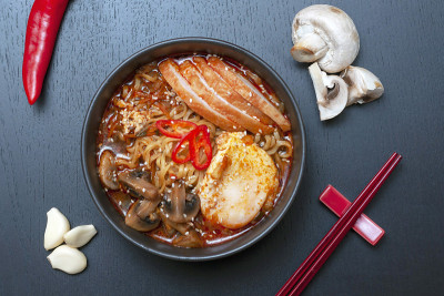 拉面是一种用筷子和配料制作的韩国传统美食。亚洲汤有面条，鸡胸肉，鸡蛋，蘑菇，汤，辣酱和香料。平的。