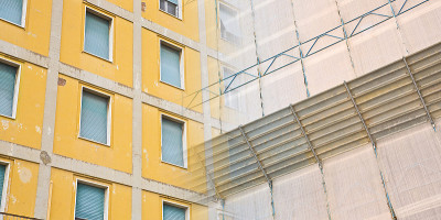 旧建筑灰泥立面修复重建用带保护油布的金属脚手架