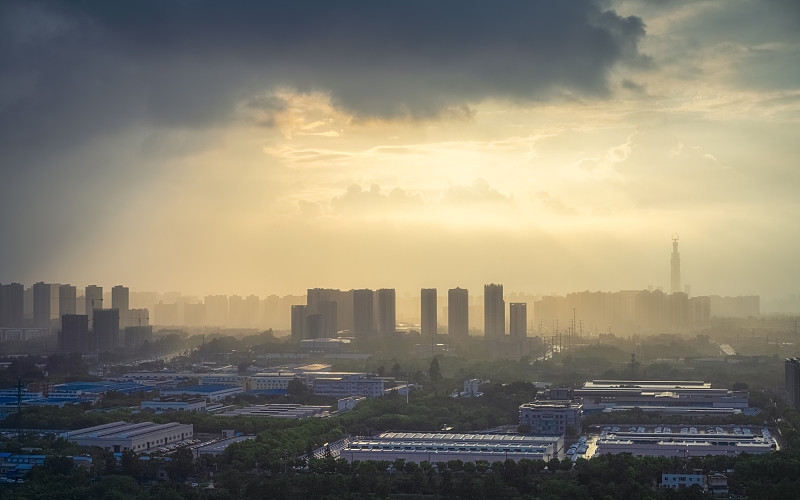 太阳在雨中穿过云层形成潮汐效应的城市