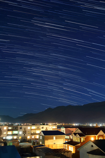 星夜在城市的山后经过房屋或建筑物