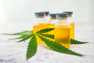 麻油装在装有绿叶的小瓶里，放在大理石桌上。替代医学概念。