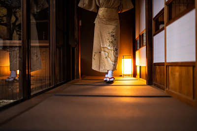 传统的日本屋屋，榻榻米地板和正二滑动纸门，妇女穿着和服和tabi袜子鞋走在走廊大厅的房间