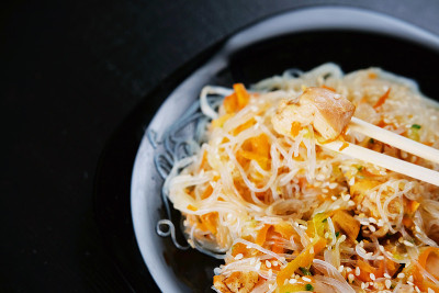 亚洲的传统食品。鸡肉炒米粉，蔬菜片撒芝麻。