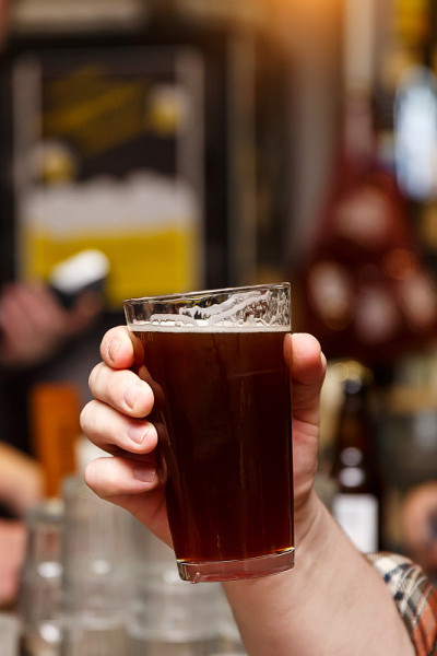 手拿精酿啤酒0.4升玻璃杯。
