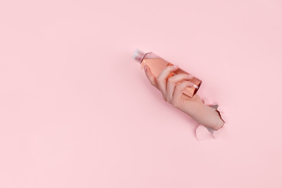 女性手拿着破纸上的透明质酸瓶