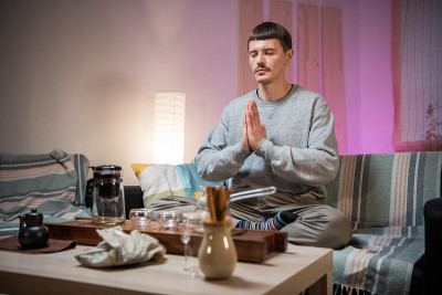 一个人在茶桌和竹盘上开始一场传统东方茶会之前，先冥想以达到与周围世界的和谐