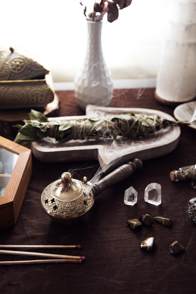 一个带有烟雾的药草燃烧器在祭坛上进行能量净化和女巫仪式的细节