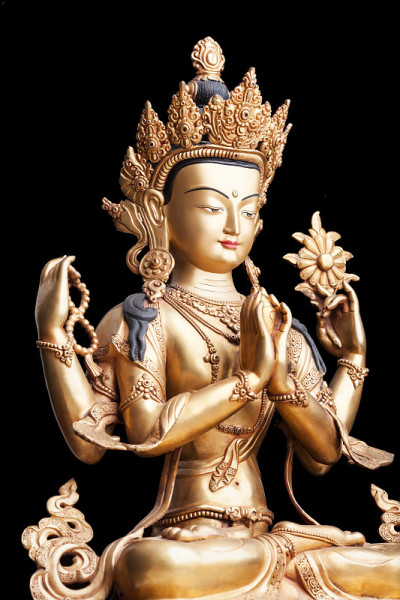 四臂形观世音菩萨由金属制成，孤立在黑色背景上。