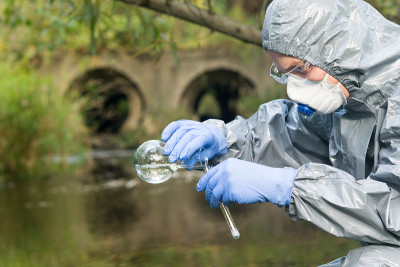 穿着防护服的工人检查河水的污染和辐射