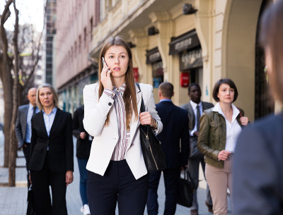 年轻的女商人在户外打电话