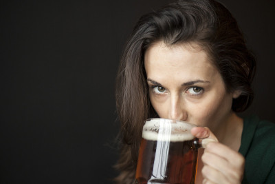 漂亮的年轻女人拿着一杯啤酒