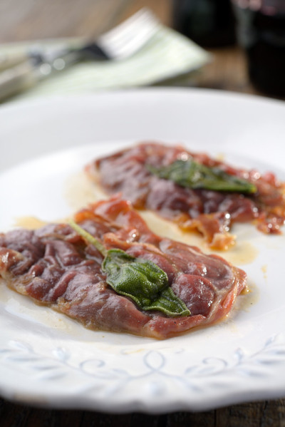 Saltimbocca真主安拉Romana放在一张质朴的桌子上