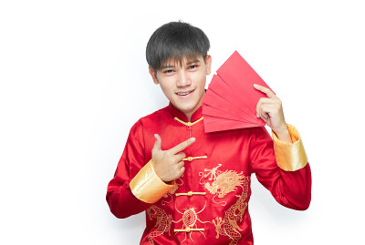 年轻的亚洲男子在普通话领连衣裙拿着红包在白色的背景与剪报路径。中国新年的概念。