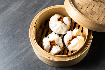 中国传统美食的概念。饺子点心在竹蒸笼内用文字抄写空间。亚洲食物背景