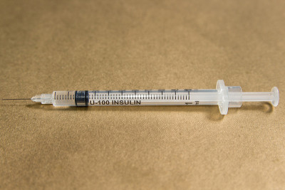 金色背景胰岛素注射器。