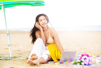 坐在海滩上的大号年轻女人。