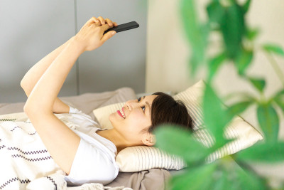 年轻女子在床上用手机