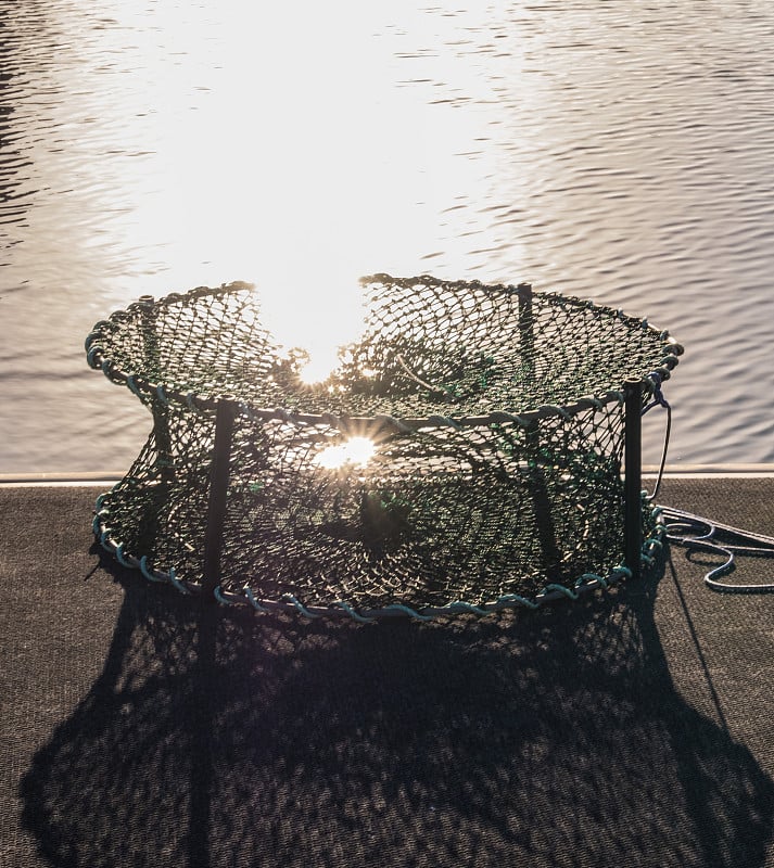 Crab trap on the platform near water.