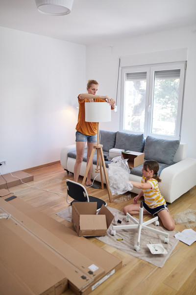 母女俩在新公寓组装家具，搬进来，辛苦工作。