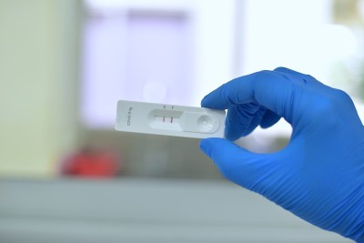 手科学家在蓝色手套测试实验室模糊背景。