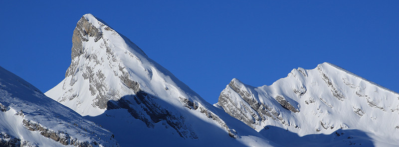 天空湛蓝，雪山覆盖着丘吉尔山脉的山峰。