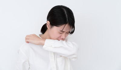 亚裔妇女在白人背景上咳嗽