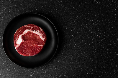 生牛肋眼肉食物牛排对黑石背景
