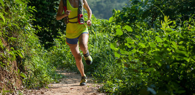 年轻女子trail runner在日出热带森林跑步
