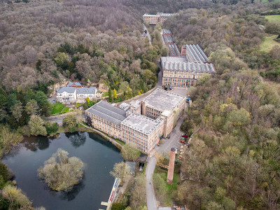 古英国工业棉纺厂建筑在山谷中，周围是被林地乡村废弃的工厂场地。废弃的烟囱磨坊池塘和森林Pleasel