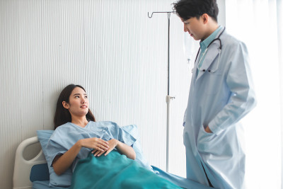 手持医生测量病人的压力。医疗工作者在检查血压或其他健康的年轻人期间。