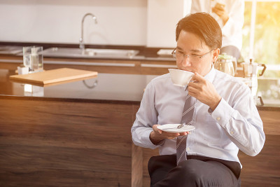 早上上班前喝热咖啡的商人。