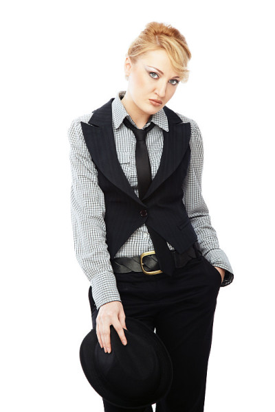 金发女人穿着时髦的商务服装拿着黑帽子