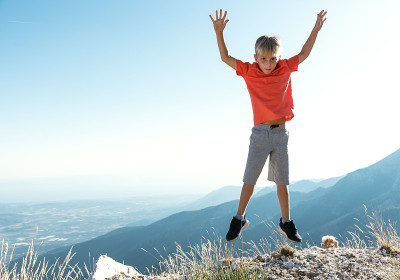 Playful Boy jumping outdoor. Copy space